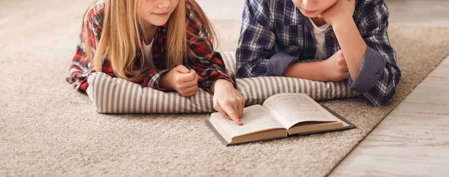 Brother And Sister Reading Book Together Doing Homework Lying On Floor At Home On Weekend. Best Friends. photo