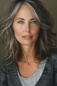 Greysweaterclad woman with gray hair and blue eyes, pleased expression photo
