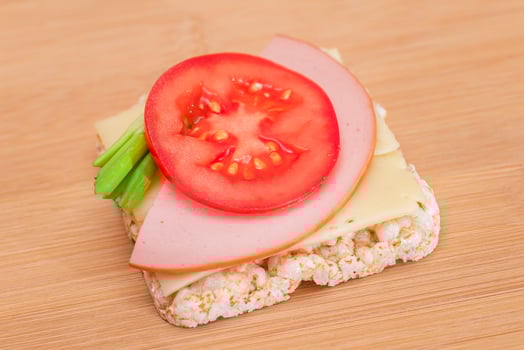 Rice Cake Sandwich with Tomato, Sausage, Green Onions and Cheese on Wooden Cutting Board. Easy Breakfast. Diet Food. Quick and Healthy Sandwiches. Crispbread with Tasty Filling. Healthy Dietary Snack photo