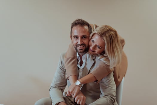 A business couple posing for a photograph together against a beige backdrop, capturing their professional partnership and creating a timeless image of unity and success. photo