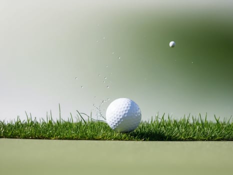 Golf ball hitting the green on a green background photo
