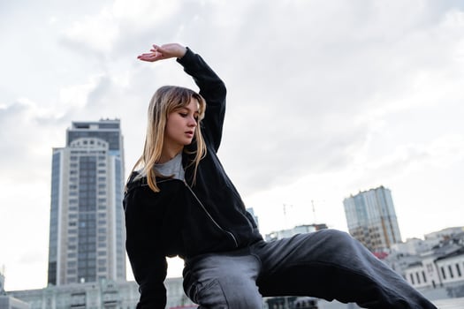 Young dancer performing a graceful movement on a rooftop in the city photo