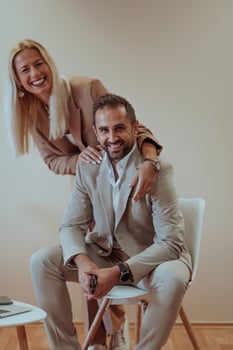A business couple posing for a photograph together against a beige backdrop, capturing their professional partnership and creating a timeless image of unity and success. photo