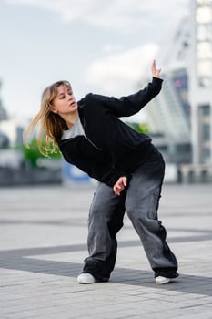 Skilled dancer performing dynamic movement outdoors in urban environment photo