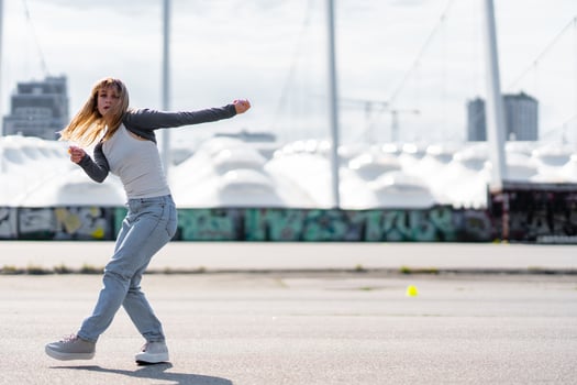 Young woman dances in urban area with modern architecture in background photo