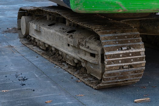 Steel caterpillar tracks of excavator on a job site, indicating recent photo