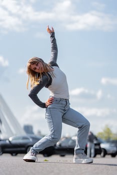 Dancer showcasing expressive moves under a bright sky in urban setting photo
