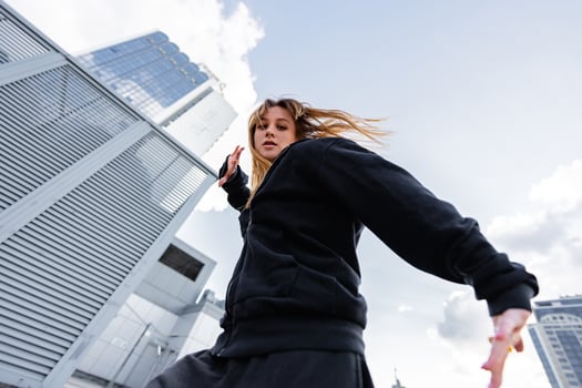 Dynamic urban dancer performing expressive movements on a city rooftop photo