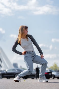 Dancer performing dynamic pose outdoors under a bright sky photo