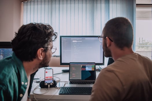 Programmers engrossed in deep collaboration, diligently working together to solve complex problems and develop innovative mobile applications with seamless functionality. photo
