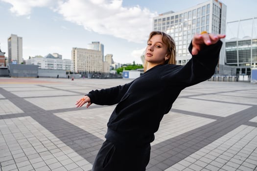 Young dancer performing in an urban plaza on a cloudy day photo