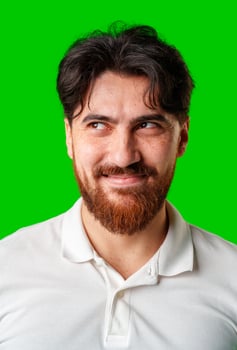 A young man with a beard showing a serious expression against a vibrant green background photo