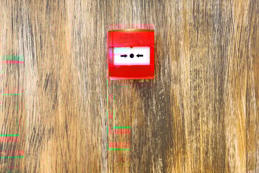 A red fire alarm on a wooden surface photo