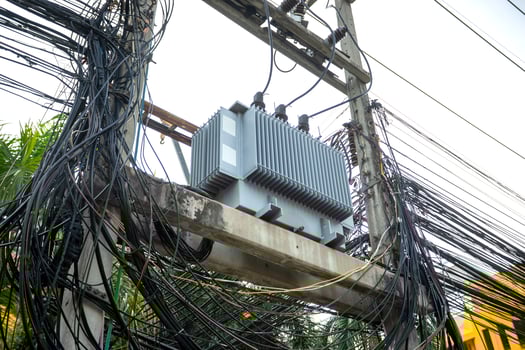A large electrical transformer is attached to a pole photo