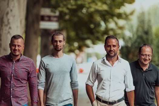 After a productive day at work, a group of diverse colleagues enjoy a leisurely stroll through a modern and natural urban setting photo