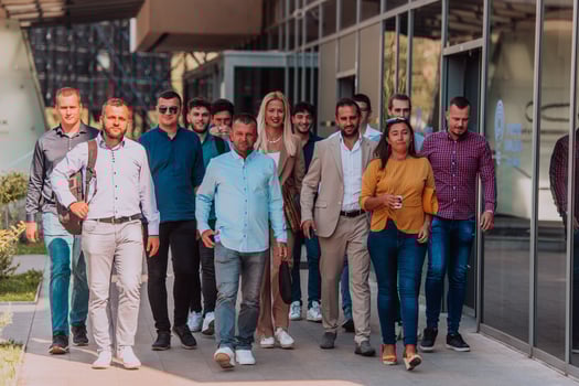 A diverse group of businessmen and colleagues walking together by their workplace, showcasing collaboration and teamwork in the company. photo