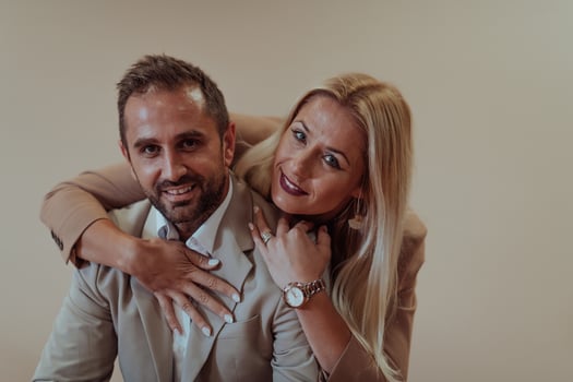 A business couple posing for a photograph together against a beige backdrop, capturing their professional partnership and creating a timeless image of unity and success. photo