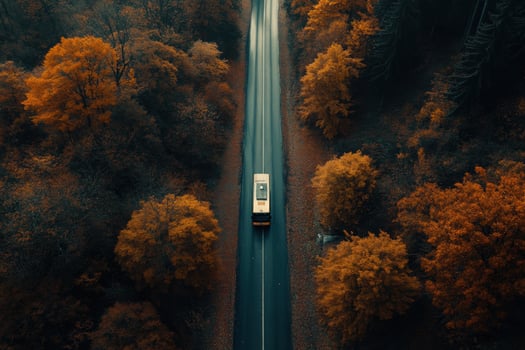 Shuttle bus traveling on a road through a forest in autumn photo