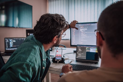 Programmers engrossed in deep collaboration, diligently working together to solve complex problems and develop innovative mobile applications with seamless functionality. photo