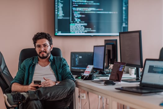 A programmer diligently testing smartphone applications while sitting in their office. photo