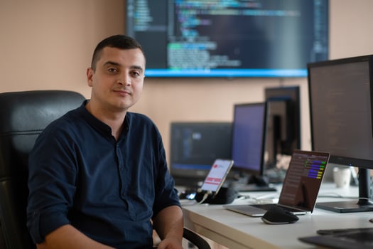 A programmer diligently testing smartphone applications while sitting in their office. photo