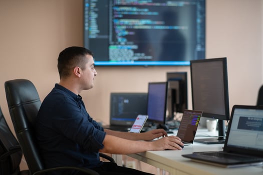 A programmer diligently testing smartphone applications while sitting in their office. photo
