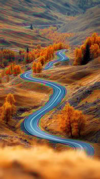 Winding road through autumn hills with golden foliage and blue sky photo