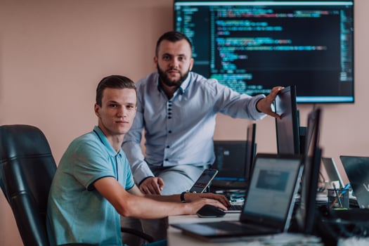 Programmers engrossed in deep collaboration, diligently working together to solve complex problems and develop innovative mobile applications with seamless functionality. photo