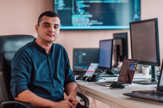 A programmer diligently testing smartphone applications while sitting in their office. photo