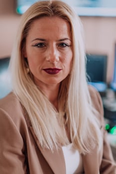 A businesswoman sitting in a programmer's office surrounded by computers, showing her expertise and dedication to technology. photo