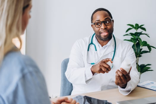 Male doctor and female patient having medical consultation prescribe pills at clinic photo
