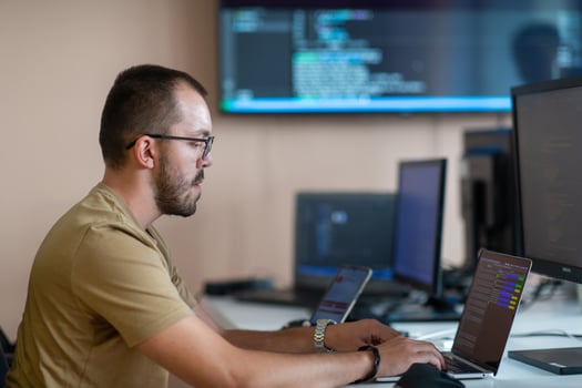 A programmer diligently testing smartphone applications while sitting in their office. photo
