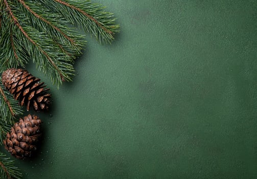 Festive pine branches and pine cones on green background photo
