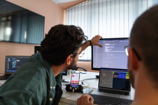 Programmers engrossed in deep collaboration, diligently working together to solve complex problems and develop innovative mobile applications with seamless functionality. photo