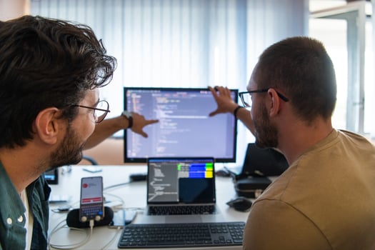 Programmers engrossed in deep collaboration, diligently working together to solve complex problems and develop innovative mobile applications with seamless functionality. photo