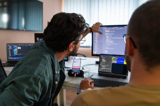 Programmers engrossed in deep collaboration, diligently working together to solve complex problems and develop innovative mobile applications with seamless functionality. photo