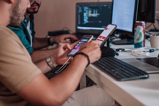 A programmer diligently testing smartphone applications while sitting in their office. photo