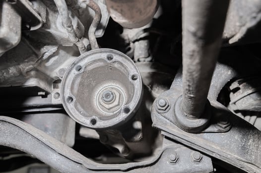 Close-up view from under the car. Dirty suspension of an off-road vehicle. Transmission components photo