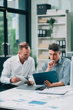 Two businessmen working together Analyze financial reports with charts and graphs while using the calculator to calculate budget, income, taxes, business growth. Startup business idea. photo