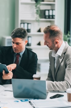 Two businessmen working together Analyze financial reports with charts and graphs while using the calculator to calculate budget, income, taxes, business growth. Startup business idea. photo