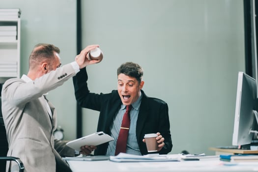 Two happy colleagues with laptop and documents in office photo