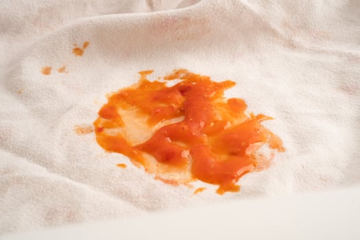 Dirty tomato sauce stain or ketchup on cloth to wash with washing powder, cleaning housework. photo