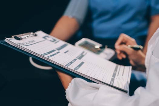 A doctor taking a patient's blood pressure. The patient's arm is equipped with a blood pressure cuff, and the doctor is using a blood pressure monitor. photo