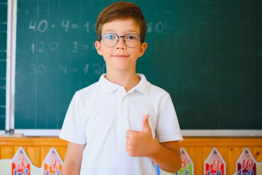 Schoolboy near blackboard in classroom photo