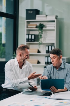 Two businessmen working together Analyze financial reports with charts and graphs while using the calculator to calculate budget, income, taxes, business growth. Startup business idea. photo