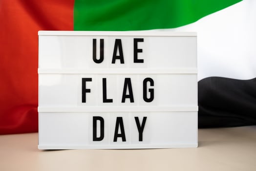 Lightbox with text UAE FLAG DAY on United Arab Emirates waving flag made from silk material. Independence Commemoration Day Muslim Public holiday celebration background. The National Flag of UAE. Patriotism photo