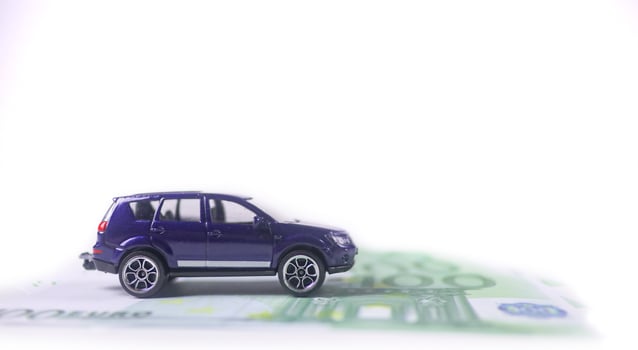 Model car with euro banknotes on white background concept of saving for buying car, car loan and car insurance. photo