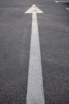 Macro photography of asphalt road texture with vertical arrow close up photo