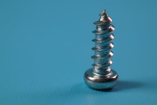 screw in closeup on blue background photo