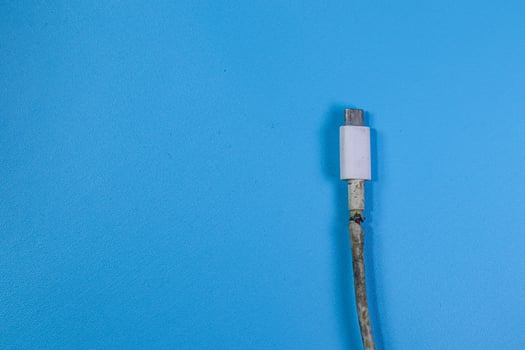 Broken Smart Phone Charger Cable on blue background photo